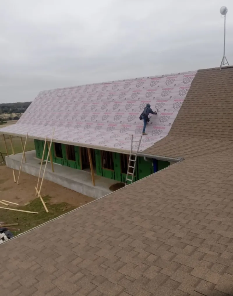 Worker preparing underlayment for a metal roof installation in Sugarland Run